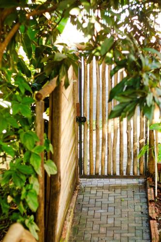 a wooden fence with a gate in a garden at Cabana Urbana in Cascavel