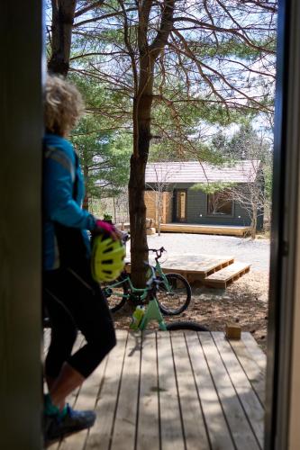 a person walking a bike next to a tree at Black Forest Cabins in Mahone Bay