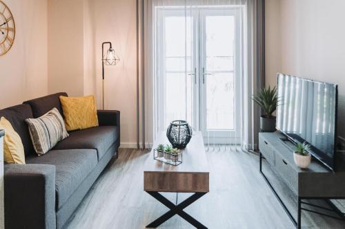 マンチェスターにある2 Bed 2 Bath Apartment Close to City Ctre Sleeps 5 -Free Parkingのソファとテレビのあるリビングルーム