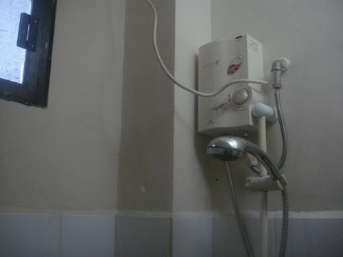 a shower in a bathroom with a hose at Hidden Pearl Hotel (Janus Luxury Suites) in Angeles