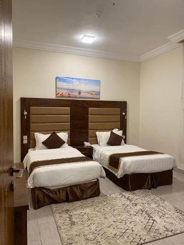 a hotel room with two beds and a rug at فندق فاتوران فرع ينبع in Yanbu