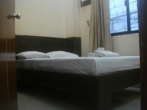a bed sitting in a room with a window at Hidden Pearl Hotel (Janus Luxury Suites) in Angeles