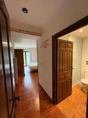 a room with a door and a bathroom with a toilet at Posada Punta Liñera in San Vicente de la Barquera