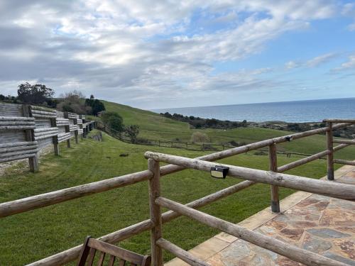 a wooden fence with a view of the ocean at Posada Punta Liñera in San Vicente de la Barquera