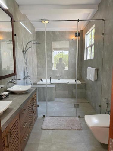 a bathroom with a shower and a tub and a sink at Sanctuary Ceylon by Ceylon Spaces in Mount Lavinia