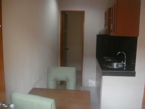 a small kitchen with a table and a sink at Hidden Pearl Hotel (Janus Luxury Suites) in Angeles
