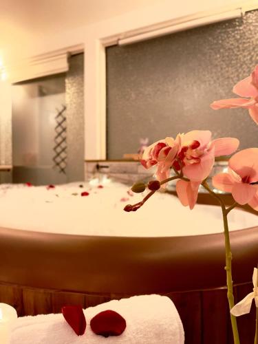 a bathroom with a bath tub with pink flowers at Saints & Sinners Romantic Jacuzzi in Bucharest