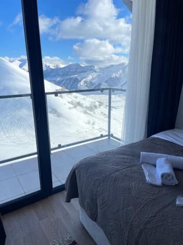 a bedroom with a view of a snow covered mountain at New Gudauri Twins in Gudauri