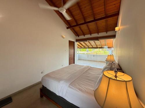 a bedroom with a large bed and a lamp at Sanctuary Ceylon by Ceylon Spaces in Mount Lavinia