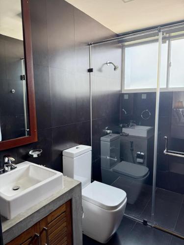 a bathroom with a toilet and a sink and a shower at Sanctuary Ceylon by Ceylon Spaces in Mount Lavinia