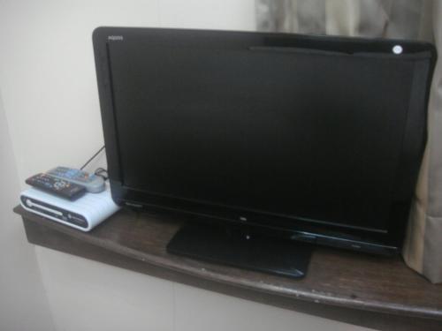 a television sitting on a shelf with a remote control at Hidden Pearl Hotel (Janus Luxury Suites) in Angeles