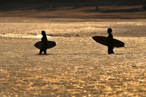 two people standing in the water with their surfboards at Cozy & Comfy 2BR Villa 7 at Playa Venao in Playa Venao