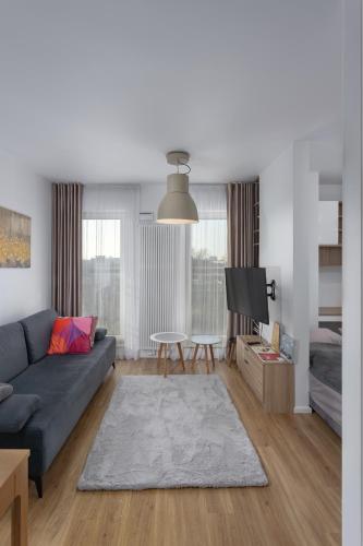 a living room with a blue couch and a tv at Soft Loft Legnicka in Wrocław