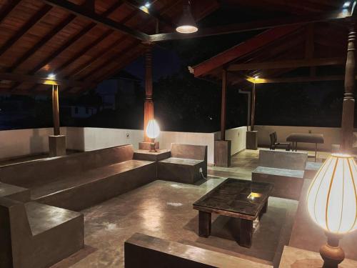 a living room with couches and a table and a lamp at Sanctuary Ceylon by Ceylon Spaces in Mount Lavinia