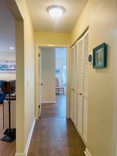 a hallway with yellow walls and wooden floors and a door at 13 Beach Stop Hilton Head in Hilton Head Island