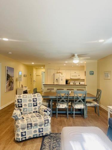 a living room with a table and chairs at 13 Beach Stop Hilton Head in Hilton Head Island