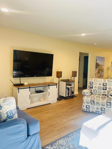 a living room with a large flat screen tv at 13 Beach Stop Hilton Head in Hilton Head Island