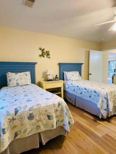 a bedroom with two beds and a table with a lamp at 13 Beach Stop Hilton Head in Hilton Head Island