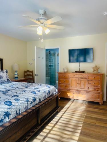 a bedroom with a bed and a ceiling fan at 13 Beach Stop Hilton Head in Hilton Head Island
