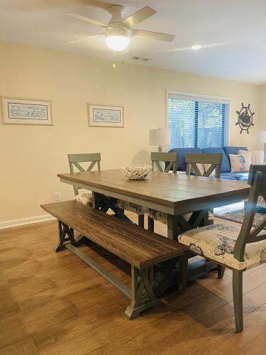 a dining room with a wooden table and benches at 13 Beach Stop Hilton Head in Hilton Head Island