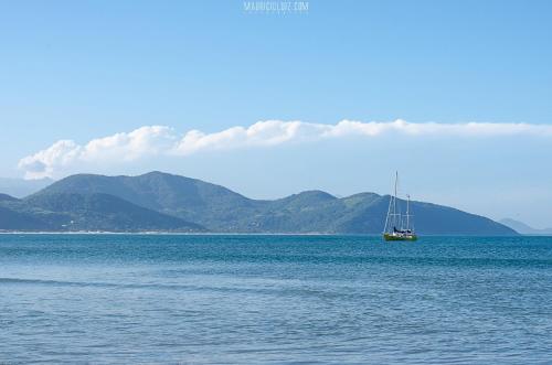 a boat in the middle of a large body of water at Pousada Bronzatto in Garopaba