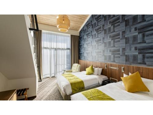 TōganeUE GARDEN RESORT - Vacation STAY 38237v的一间有两张床和一堵石墙的酒店房间