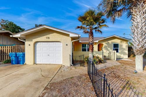 a house with a garage and a palm tree at The MOasis in Panama City Beach