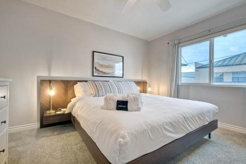 a white bedroom with a large bed with a window at 3080 Lincoln - Unit 12 in Carlsbad