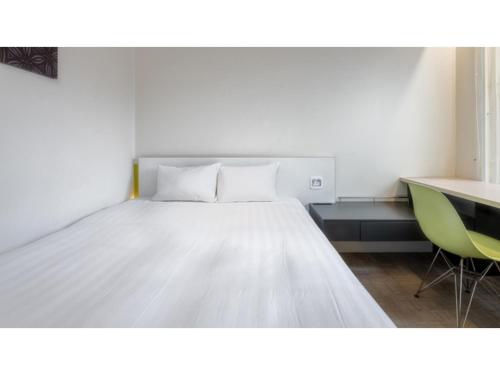 a bedroom with a bed and a desk with a green chair at The OneFive Sendai - Vacation STAY 35241v in Sendai