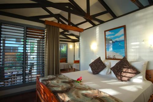 - une chambre avec un lit et une grande fenêtre dans l'établissement Nanuya Island Resort, à Nanuya Lailai