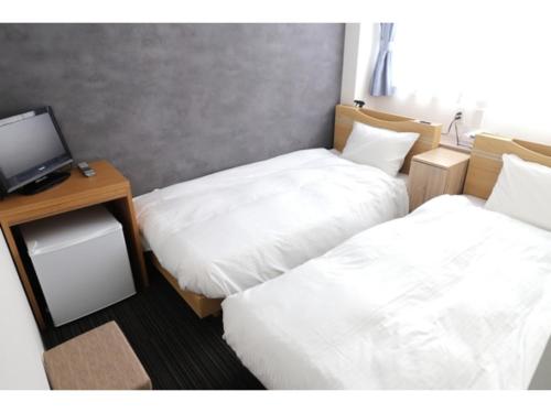 a room with two beds and a desk with a computer at Business Hotel B,loom - Vacation STAY 38188v in Tanabe