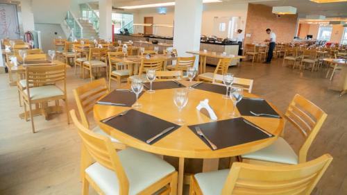 een eetkamer met een houten tafel en stoelen bij Resort Varanda Salinas Park in Salinópolis