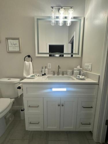 a bathroom with a sink and a toilet and a mirror at Richland Villa in Vidalia