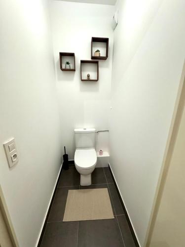a bathroom with a toilet and two pictures on the wall at Charming 3BR Apartment with Loggia close to Paris in Le Plessis-Robinson