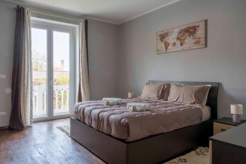 a bedroom with a bed and a large window at Casa vacanza Nada in Dogliani