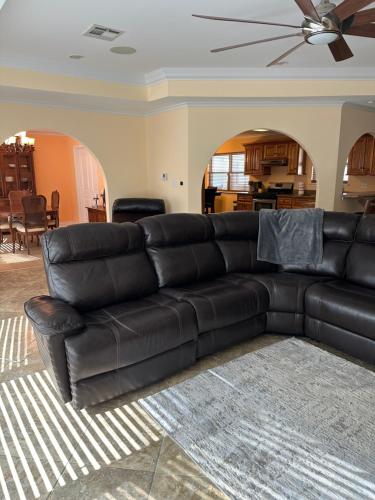 a black leather couch in a living room at New Orleans Ponderosa in New Orleans