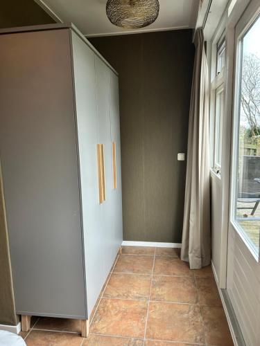 a room with a white cabinet and a window at Appartement Sluyterman in Jorwerd