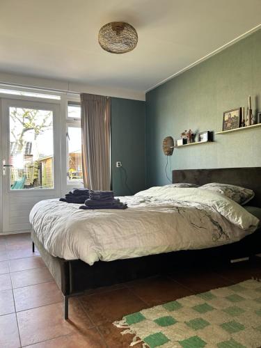 a bedroom with a large bed and a window at Appartement Sluyterman in Jorwerd