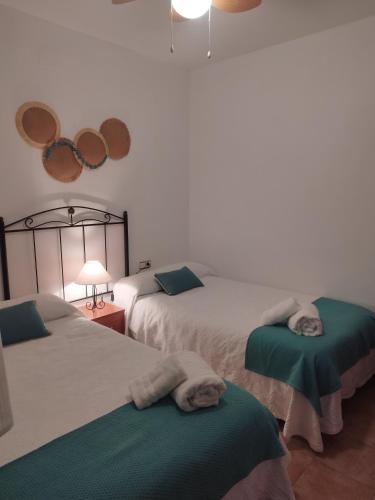 a bedroom with two beds with towels on them at Alojamiento el camarín in Baños de la Encina