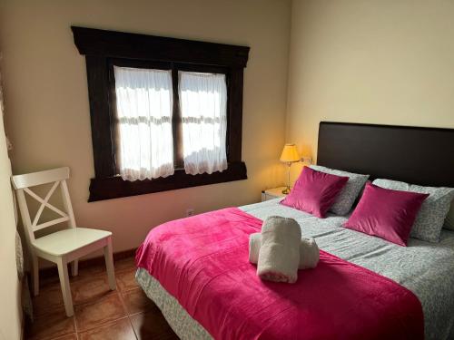 a bedroom with a large bed with a pink blanket at CASA CON FINCA PRIVADA in Moaña