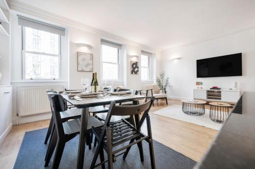 a dining room and living room with a table and chairs at 2 Bedr, 3 Beds, 1 Bath Thames, Trafalgar SQ in London