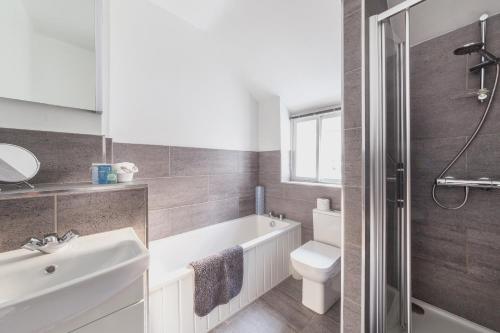 a bathroom with a sink and a toilet and a bath tub at Cosy Cottage in the Heart of Charnwood Forest in Woodhouse