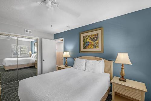 a bedroom with a large white bed and blue walls at Ocean View at Island Club in Hilton Head Island