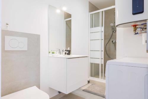 a white bathroom with a sink and a shower at Comfortable Studio for 2 people - Puteaux in Puteaux