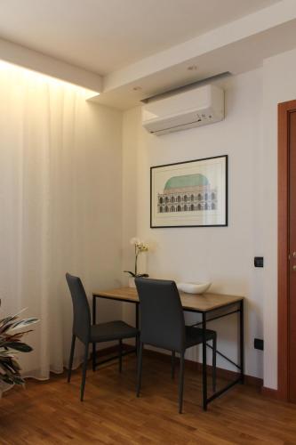 a dining room with a table and two chairs at La Basilica Luxury Apartment - Close to the City Center and Fiera di Vicenza in Vicenza