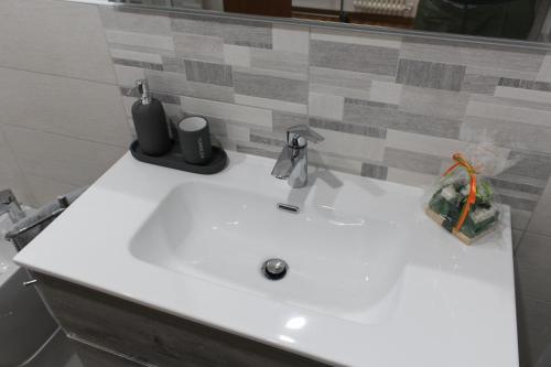 a white sink in a bathroom with a mirror at La Basilica Luxury Apartment - Close to the City Center and Fiera di Vicenza in Vicenza