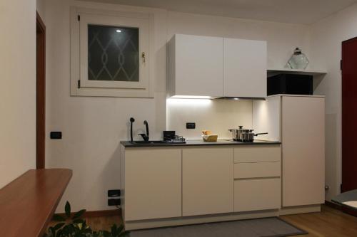 a kitchen with white cabinets and a white refrigerator at La Basilica Luxury Apartment - Close to the City Center and Fiera di Vicenza in Vicenza