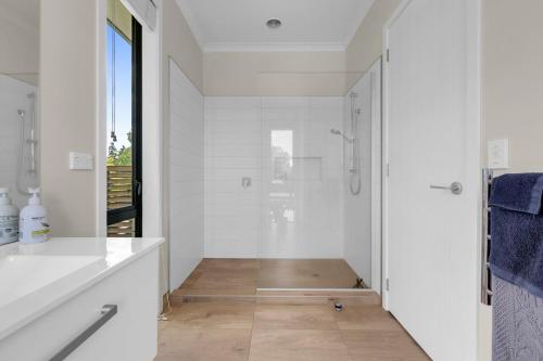 a bathroom with a walk in shower and a shower at Peter's Puketaha Homestay in Ruakura Junction