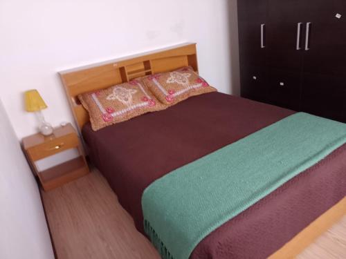 a bedroom with a large bed with a wooden headboard at El Refugio al Norte del Fin del Mundo in Río Grande