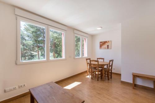 a dining room with a table and chairs and windows at El cuartel - Avila in Villatoro